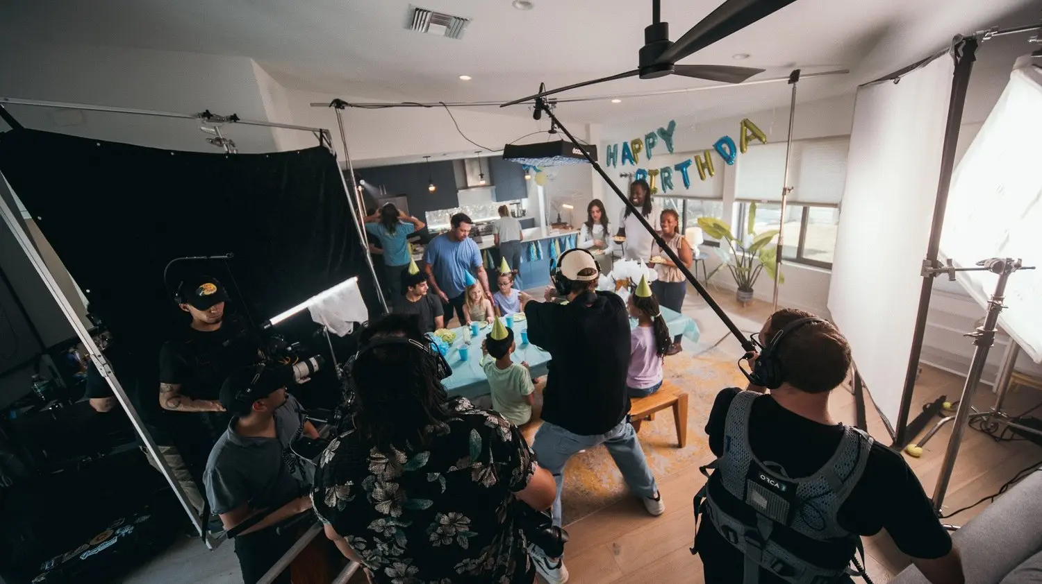 The Kyle Loftus Studios crew filming a birthday-party set with boom and lighting rigs